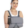 Person wearing a shoulder immobilizer to restrict shoulder and upper arm movement after injury or surgery.