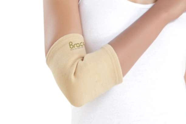 Close-up of the Braceon elbow brace worn on a person's arm, showing adjustable straps and snug fit around the elbow.